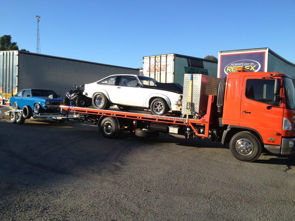 Drag cars and a motorbike loaded for transport by MTJ Towing
